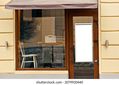 Rectangular Sign On The Building. Copy Space And Space For Text. Mockup For Design. Blank Template For Advertising. White Frame On A Glass Case. Advertising On The Window Of A Restaurant Or Shop.