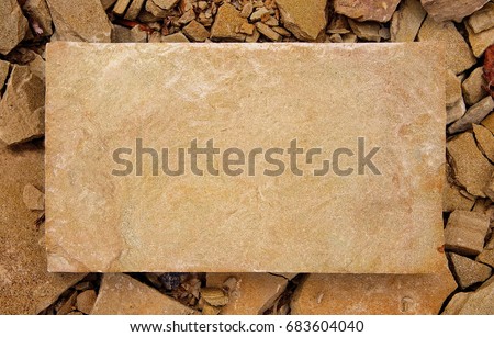 A rectangular slab of light sandstone against the background of stone fragments as the framework for your text. Light stone plate with copy space for text.
