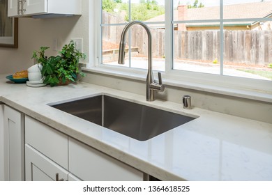 Rectangular stainless steel sink under granite countertop and with white wood  cabinet