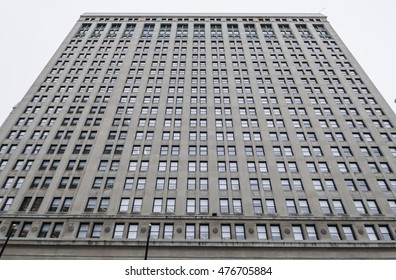 A rectangular tall building bottom upwards view on a cloudy day