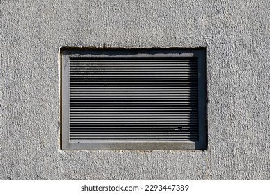 Rectangular ventilation grill in a gray concrete wall