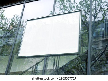 Rectangular white billboard Mockup on glass window. Empty frame on company building frontage