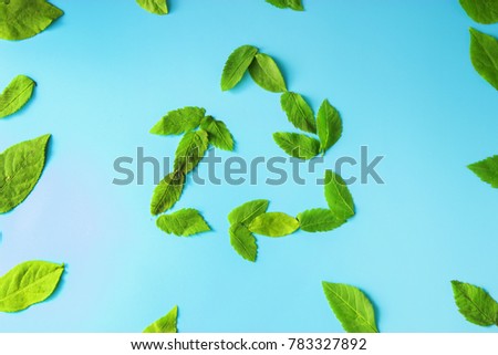 recycable sign with green leaves on blue background