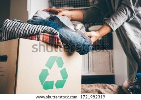 Recycle clothes concept. Recycling box full of clothes.
