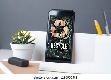 Recycle Sign On Green Leaf On Mobile App At Office Desk With Plant And Notebook.enviroment Eco System Concept