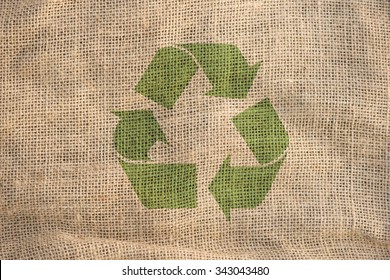 Recycle Symbol On Rough Textile Fabric. Concept Of Environment, Recycling And Eco Awareness.