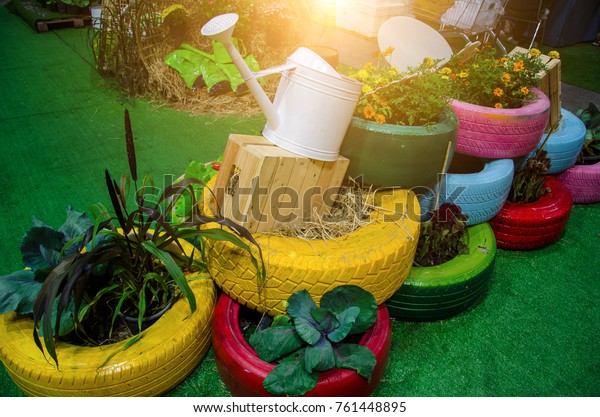 Recycle tires wheel on yard, paint\
the color used flowerpot,plant vegetables  for decorated the garden\
with sunlight.Concept create value from the\
waste.