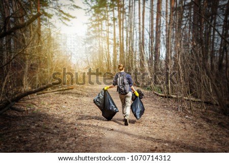 Recycle waste litter rubbish garbage trash junk clean training. Nature cleaning, volunteer ecology green concept. Young woman pick up spring forest at sunset . Environment plastic pollution