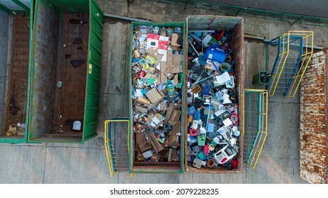 recycled materials at a garbage collection point at the tip or recycling park in Antwerp. Paper, cardboard and plastic in empty container. Drone aerial top down shot