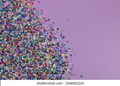 Recycled Plastic Pellets Collected From The Sea Water, Flatlay On A Lilac Purple Background.  Colorful Pieces. Rethinking The Environment By Reducing Or Reusing Plastics. Circular Economy Concept