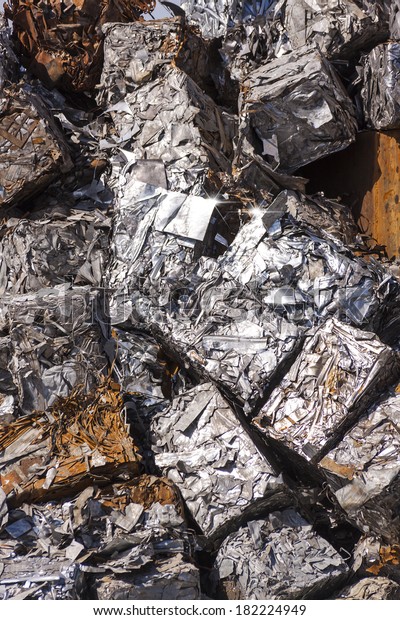 Recycled Scrap Metal Cubes - Cubes of crushed\
metal loosely stacked in a large\
pile.