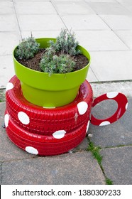 Recycled Tyres Made Into A Red And White Spotted Teacup Planter With Green Plantpot