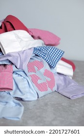 Recycling Arrows Made From A Checked Shirt On A Pile Of Clothes. Ecological And Sustainable Lifestyle. High Quality Photo