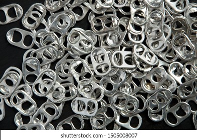 Recycling Beer and Pop Can Aluminum Tabs on Black Background Horizontal