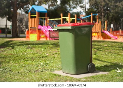 Recycling Bin Stands Outdoor Near Playground. Australia, Melbourne. Green Bin. 