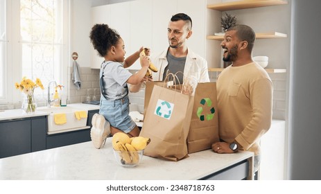 Recycling, blended family or adoption with a girl and gay couple in the home kitchen for sustainability. LGBT, eco friendly or waste with a daughter and parents unpacking bananas from a grocery bag - Powered by Shutterstock