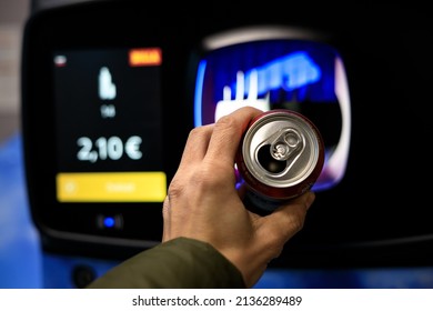 recycling a can for cash in a supermarket by throwing it into a recycling machine - Shutterstock ID 2136289489