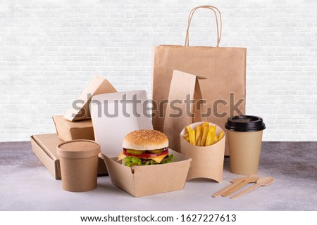 Recycling concept. Delivery food background. Fast food eco packaging with tasty hamburger, french fries, paper coffee cup and soup