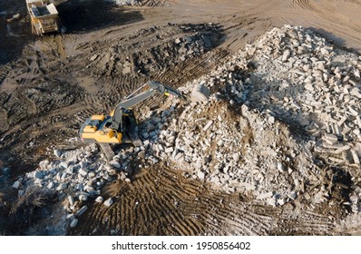 Recycling concrete and construction waste from demolition. Excavator at landfill of the disposa. Reuse of building rubble. Backhoe dig gravel at mining quarry on blue sky background. Out of focus - Powered by Shutterstock