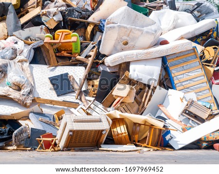 Recycling dump with trash of broken chairs, tables, bed and much more.