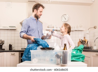 Recycling and ecology - happy caucasian family (father and daughter) sorting (segregating) household waste in the kitchen. Lifestyle - ecological education and awareness concept. - Powered by Shutterstock