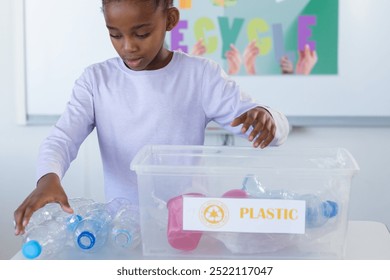 Recycling plastic bottles, african american girl in school classroom. sustainability, conservation, eco-friendly, education, green - Powered by Shutterstock