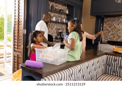 Recycling plastic, family of four sorting waste in kitchen together. environment, sustainability, waste management, household, teamwork, eco-friendly - Powered by Shutterstock