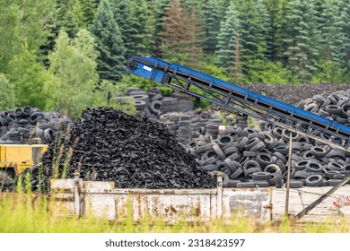 recycling and processing of old tires, crushed rubber go on a conveyor belt to a container