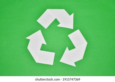 Recycling symbol cut out of white paper on green background. Copy space, top view. - Shutterstock ID 1915747369