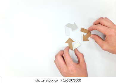 Recycling symbol made of old cardboard paper in white background. Flat lay composition with human hands. - Shutterstock ID 1658978800