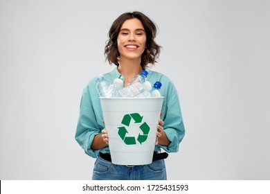 recycling, waste sorting and sustainability concept - smiling young woman in striped t-shirt holding bucket with plastic bottles over grey background - Powered by Shutterstock