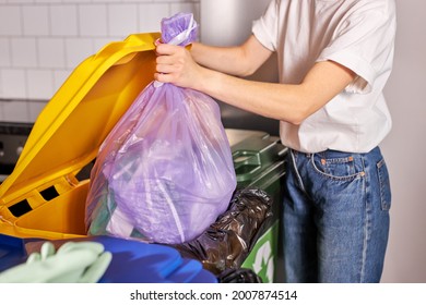 recycling, waste sorting and sustainability concept. young caucasian woman throwing rubbish in trash can, cropped female is casually dressed. side view portrait. copy space - Powered by Shutterstock