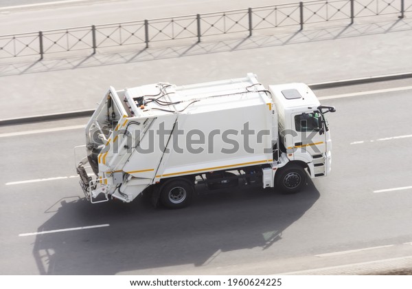 Recycling white\
truck rides on the road in the\
city
