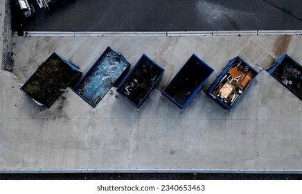 recycling yard with a ramp for dumping and sorting waste into containers. glass. Materials such as glass, metal, wood have their own boxes. vertical view from above