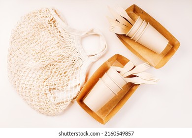 Recycling,eco-friendly Concept.Disposable Eco Cutlery,plates,spoons,knives,forks On A Light Background.Fabric Bag For Food Delivery.Eco Craft Paper Tableware.Paper Cups,fast Food Containers.Copy Space