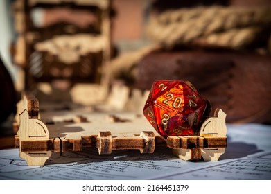 A red 20-sided role-playing gaming die on a dice tower tray