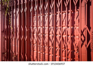 Red Accordion Iron Door In Front Of Garage Door 