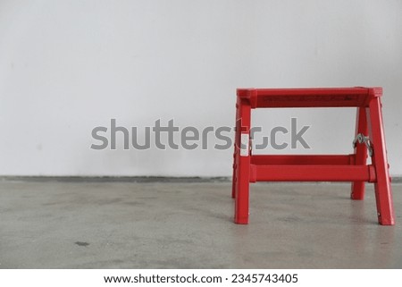 Red aesthetic step stool with whitewall as a background