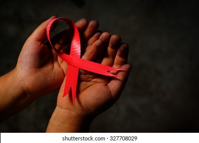 Red Aids Ribbon In Hand.