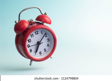 Red alarm clock. Flying alarm clock. Red alarm clock on a blue background.