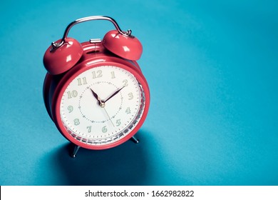 Red alarm clock on the color background. 