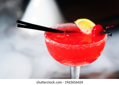 Red alcoholic cocktail in glass with cherry and lemon wedge in hookah smoke on table. close-up - Powered by Shutterstock