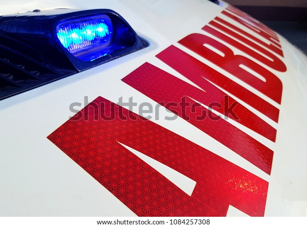 Red ambulance\
inscription and blue light 