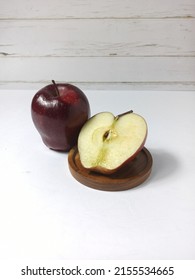 Red Apple. Close View, Selective Focus On Fresh, Delicious Of Ruby Red Apples, And Cutting Apple On Round Wood Tray. White Base And Background With Line Pattern. Malus Domestica 'Red Delicious