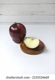 Red Apple. Close View, Selective Focus On Fresh, Delicious Of Ruby Red Apples, And Cutting Apple On Round Wood Tray. White Base And Background With Line Pattern. Malus Domestica 'Red Delicious