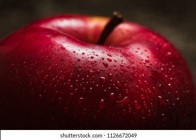 Red apple close-up. Fresh red apple on a black texture background. Apples with droplets of water. Text space. Healthy food for vegetarians.