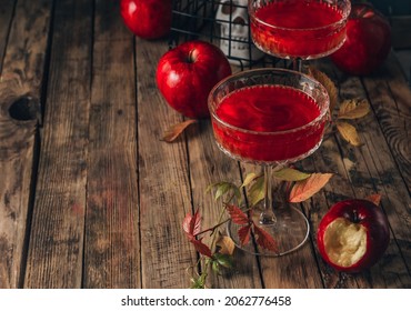 Red Apple Cocktail With Shimmer For Halloween Party On Wooden Rustic Backgroud. Selective Focus With Copy Space