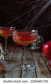 Red Apple Cocktail With Shimmer For Halloween Party On Wooden Rustic Backgroud. Selective Focus