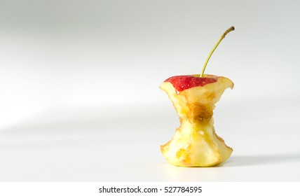 Red apple core on white table in windows light