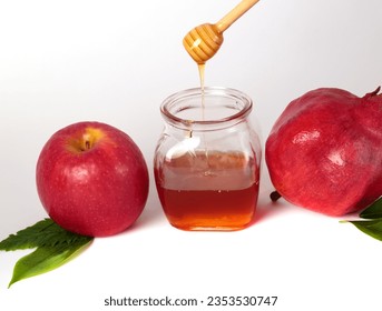 Red apple, pomegranate and honey jar on a white background for Happy Rosh Hashanah concept. Traditional Jewish holiday symbol New Year. Shana tova. Place for text, poster. Honey pot and fresh apple - Powered by Shutterstock